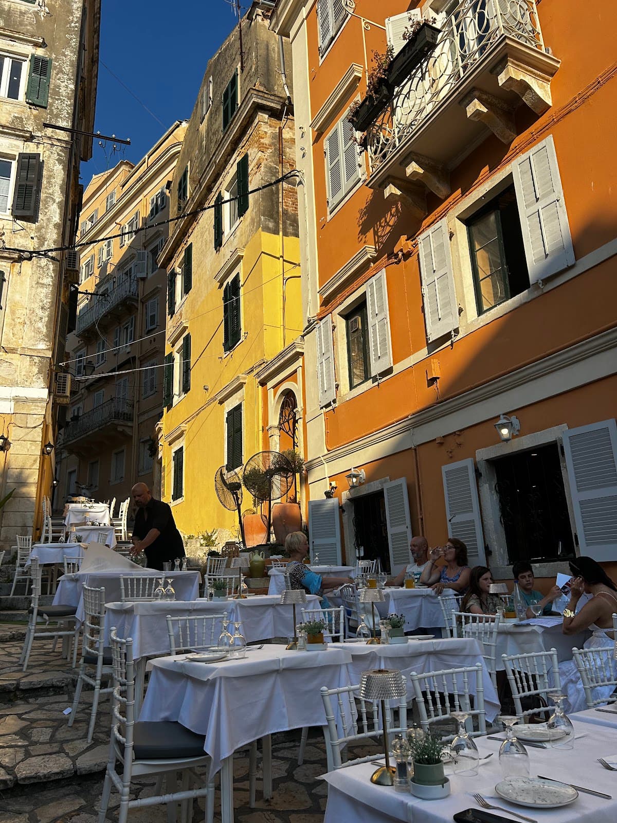 Terrace dining with guests and old town buildings